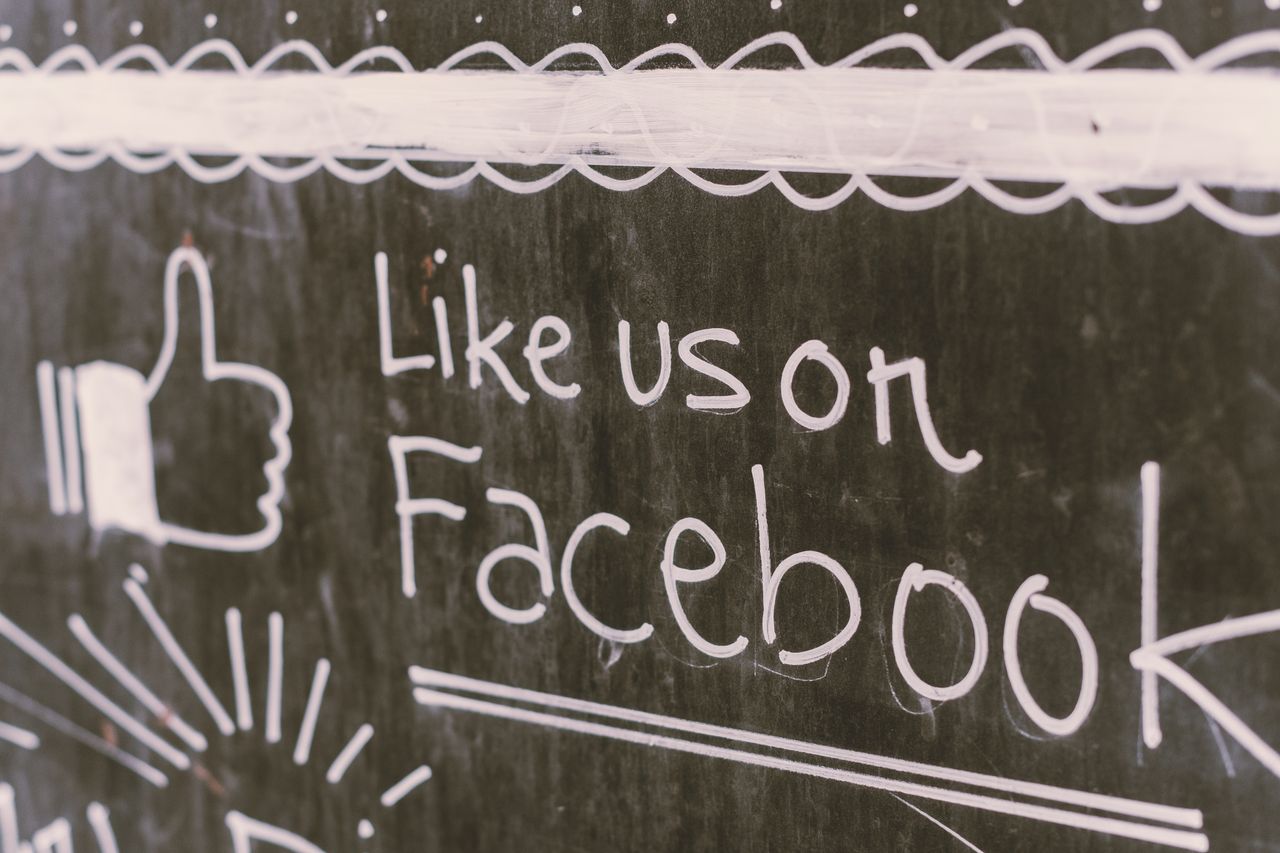 Illustration de tableau noir mettant en avant l’engagement sur Facebook avec un message pour nous aimer.